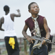 MONROVIA, LIBERIA - JULY 30 - A child Liberian militia soldier loyal to the government walks away from firing while another taunts them on July 30, 2003 in Monrovia, Liberia. Sporadic clashes continue between government forces and rebel fighters in the fight for control of Monrovia.